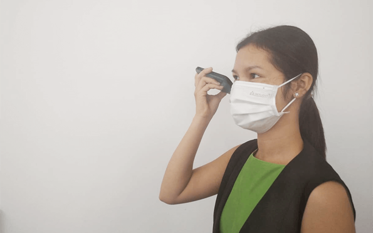 Cambodgienne avec masque ecoutant un message vocal 2