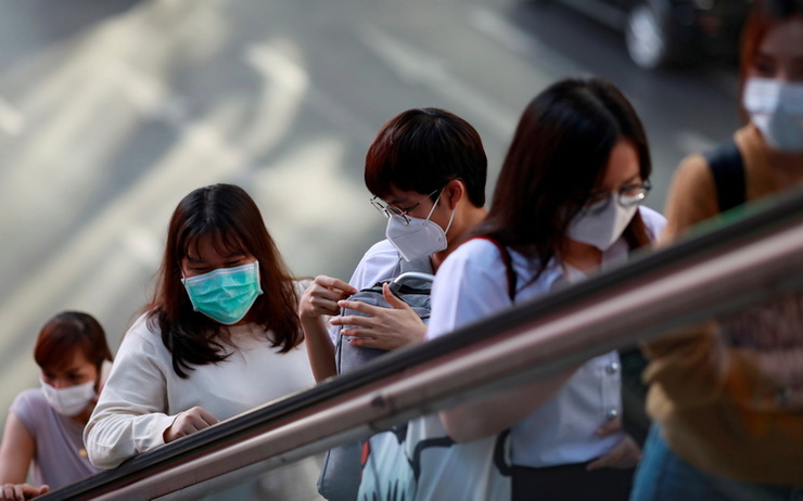 Des Thailandaises sur un escalator portent le masque durant la crise du coronavirus