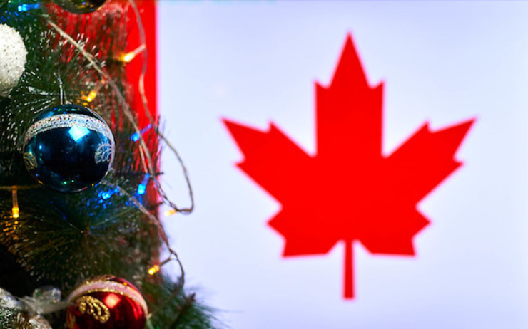Un drapeau canadien avec un sapin de Noël au premier plan