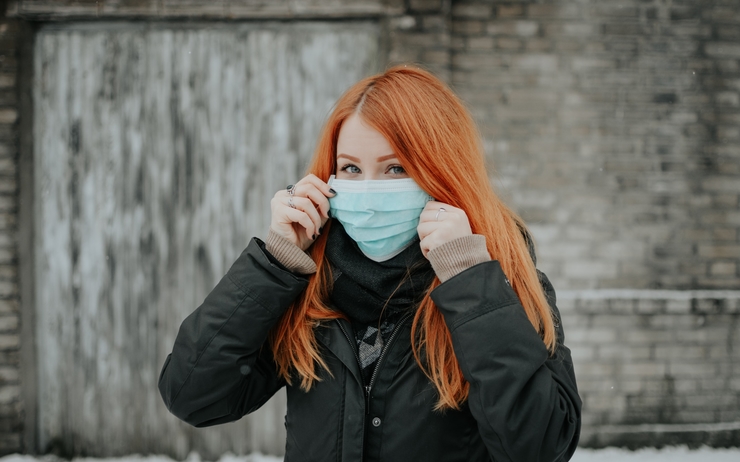 femme rousse avec un masque contre le covid en Suède