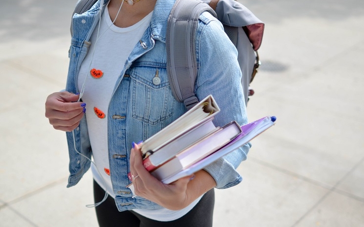 une étudiante avec des livres scolaires dans la main, en Catalogne