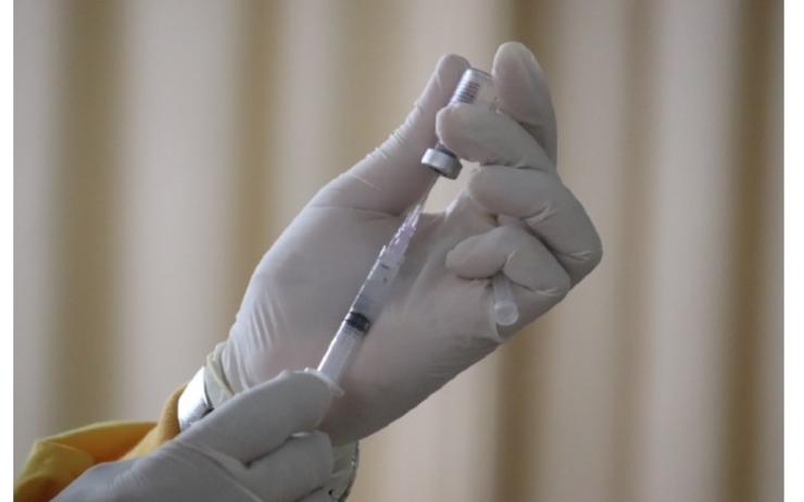 une main preparant une injection de vaccin