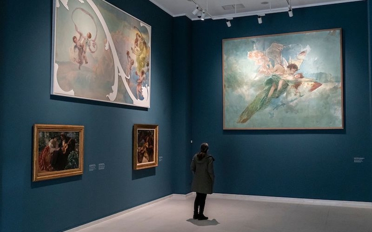 une personne en train de regarder des tableaux dans un musée