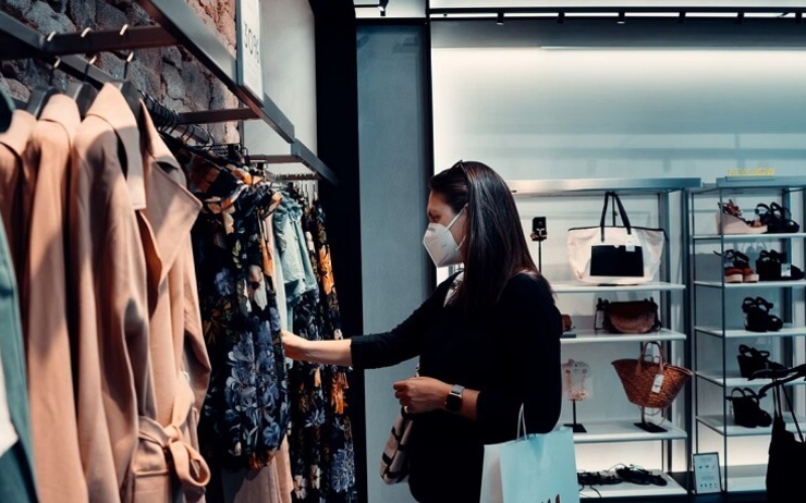 une femme dans un magasin de vêtements avec un masque FFP2