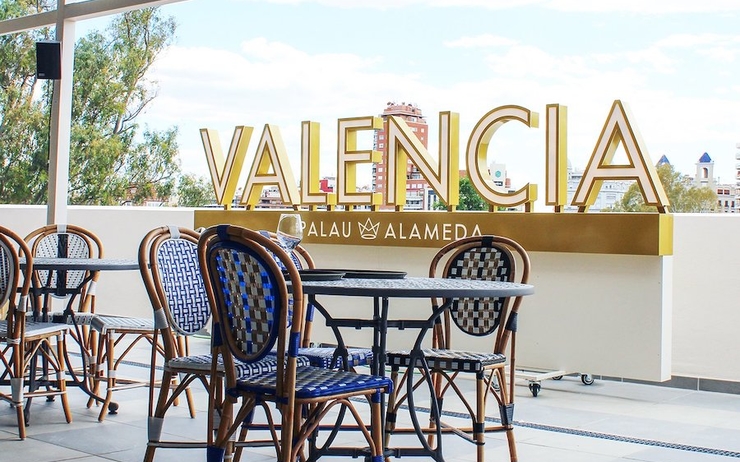 une terrasse avec des chaises bleues et des tables à Valencia