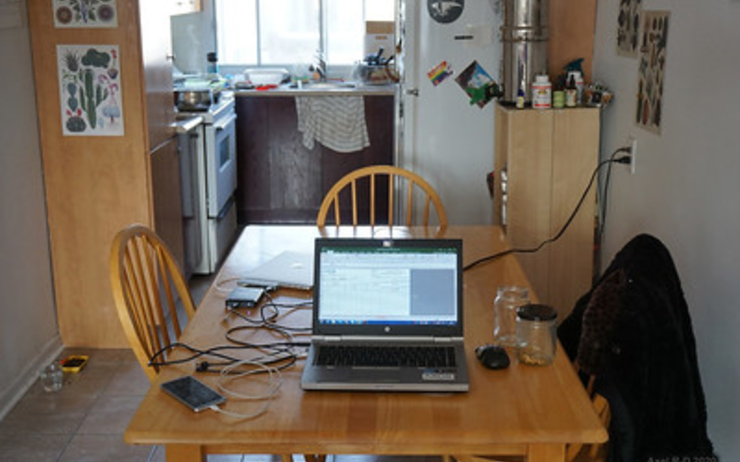 Une image de télétravail avec un ordinateur allumé sur la table de la cuisine