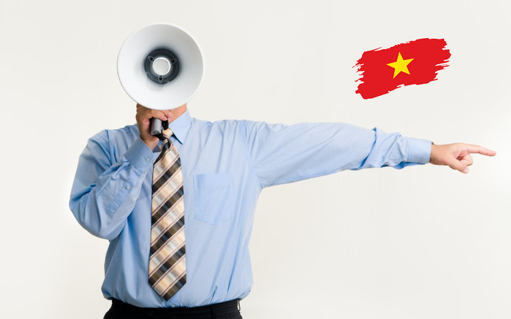 Une personne avec un mégaphone et un drapeau du vietnam dans le coin de l'image