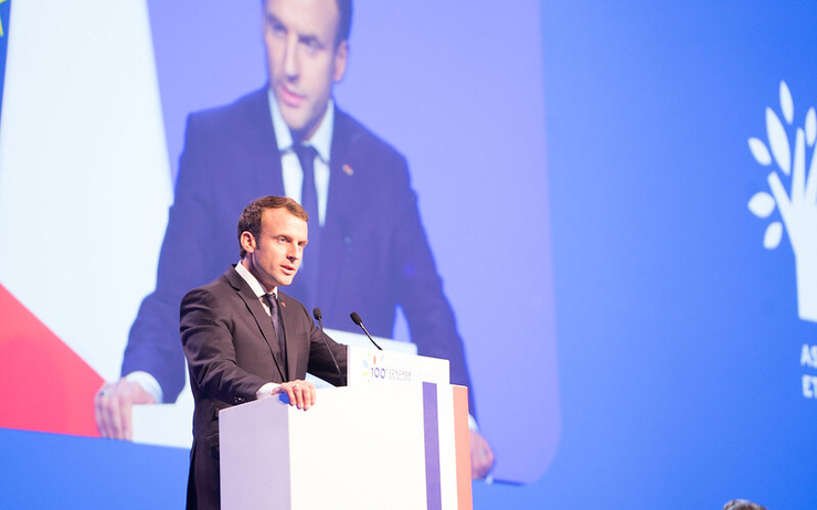 Le président Emmanuel Macron en train de parler sur un pupitre avec le drapeau français