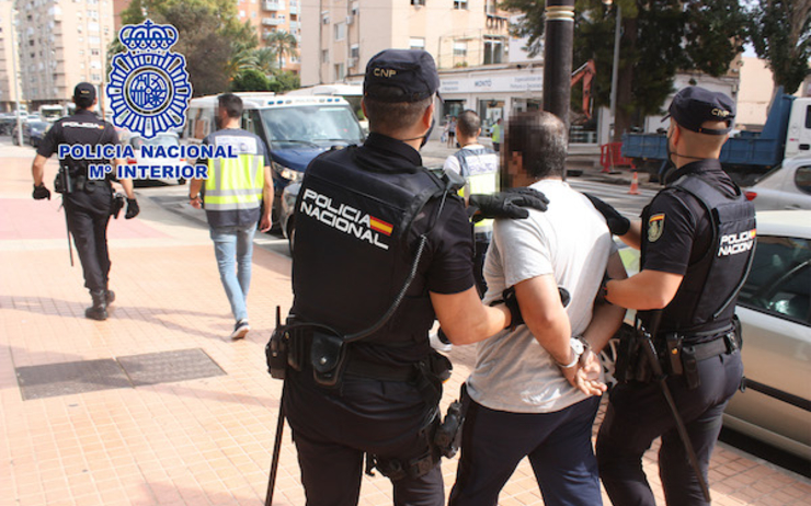 deux policiers espagnols arrêtent un individu