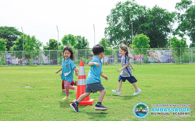 Des enfants courent sur le terrain de sport de l'école bilingue ABA Chiang Mai