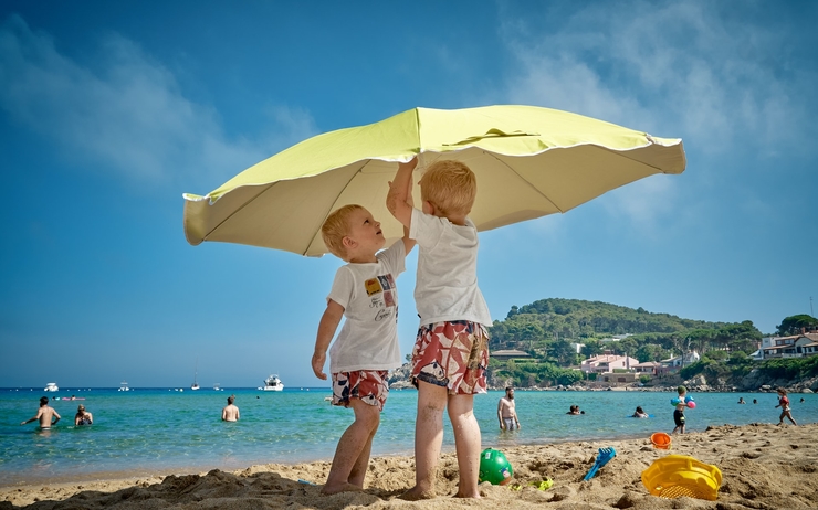 deux enfants sous un parasol jaune a la plage d'alicante