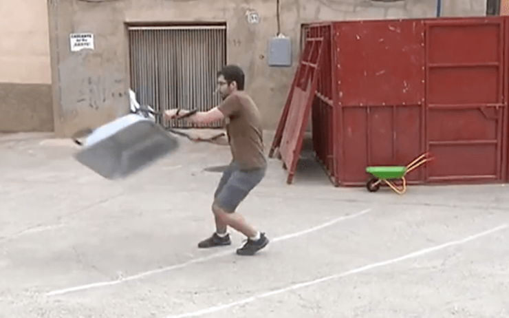un homme lance une brouette dans la rue en Espagne 