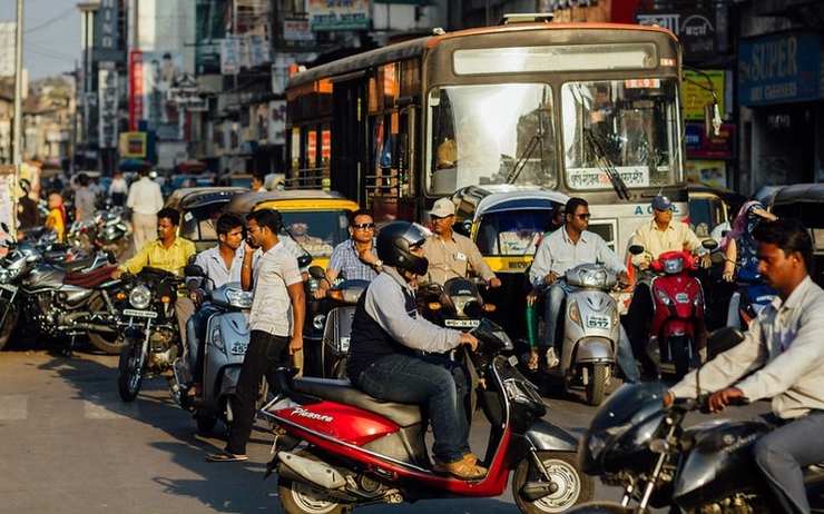 voitures scooters et bus dans tous les sens à un carrefour en Inde