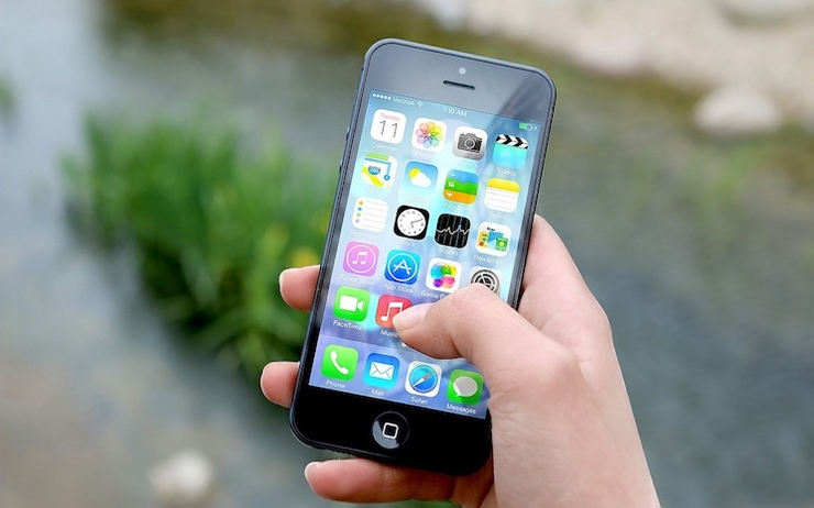 Une personne tape sur son smartphone à la recherche d'une application mobile