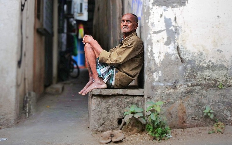 Un vieil homme dans une ruelle d'un bidonville de Mumbai