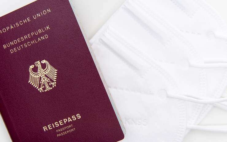 Photo d'un passeport allemand posé sur des masques de protection 