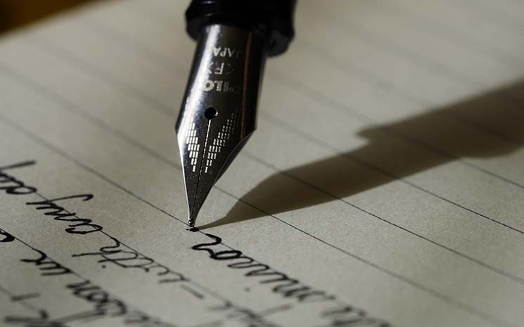 un stylo a plume en train d'écrire