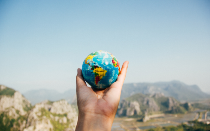 Une personne tenant un globe terrestre montrant les meilleurs pays où travailler en 2022