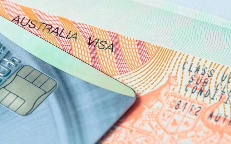Le visa australien posé sur une table avec une carte de crédit dessus 