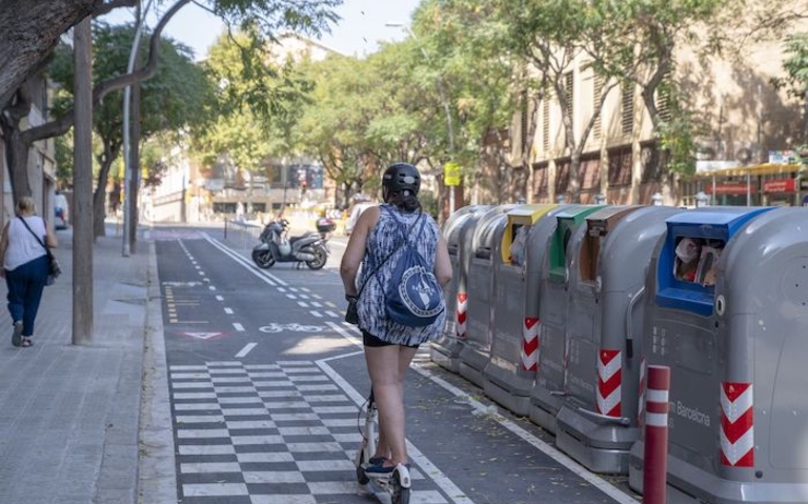 Une femme roule en trotinette à barcelone: 