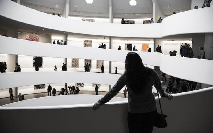 une femme observe les oeuvres dans une salle d'exposition