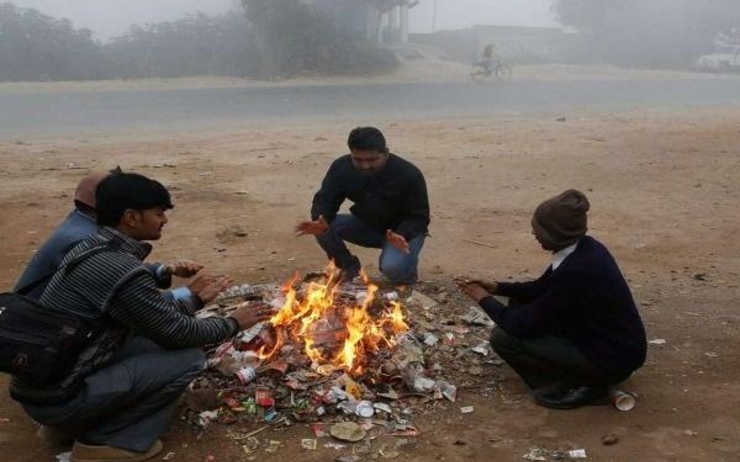 Des hommes se chauffant devant un feu de bois en Inde du nord