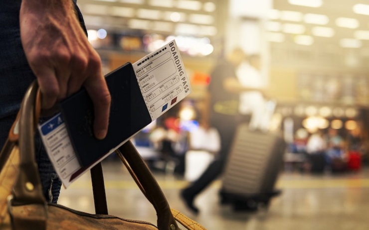 un voyageur tient sa carte d'embarquement à l'aeroport:
