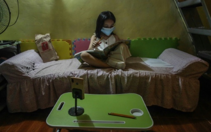 Jeune philippine étudie sur son lit
